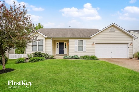 a beige house with a lawn in front of it