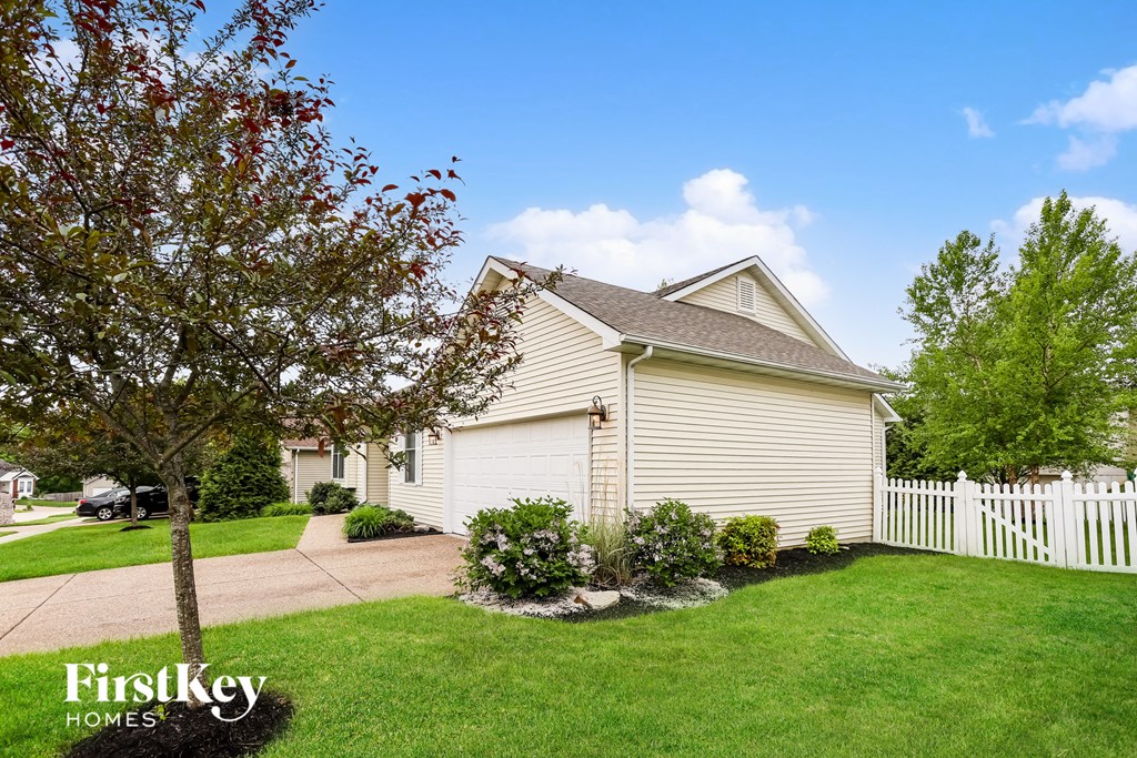 a white house with a yard and a white fence