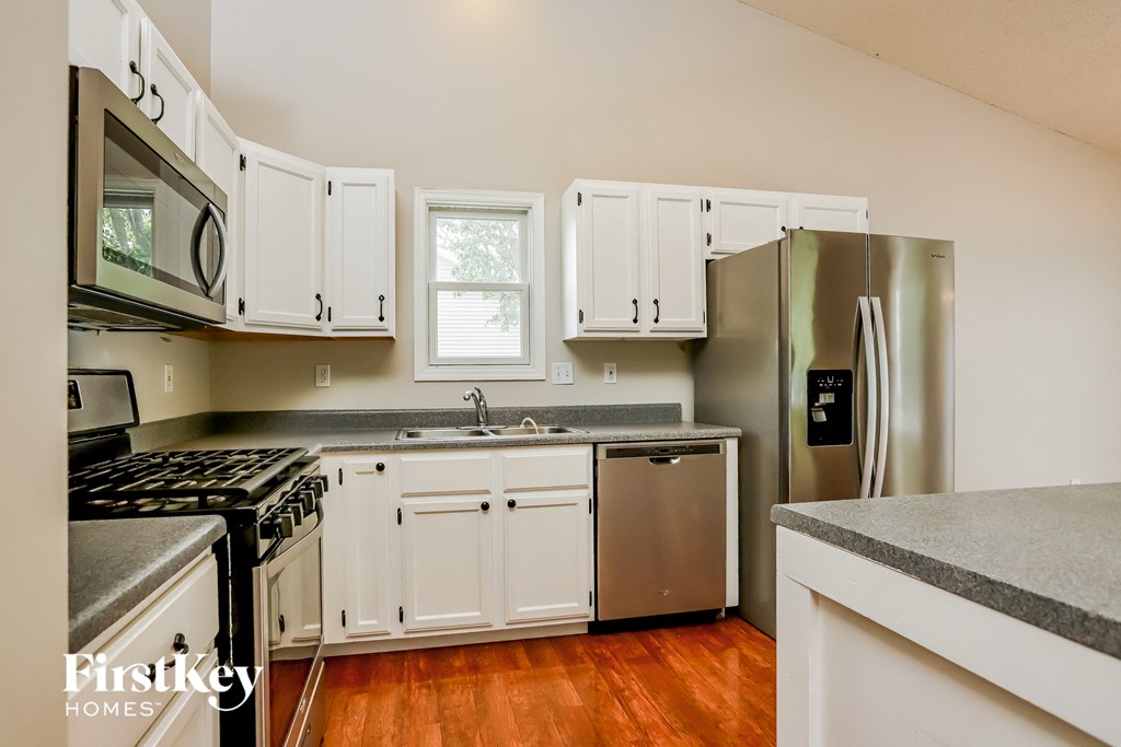 a kitchen with white cabinets and stainless steel appliances