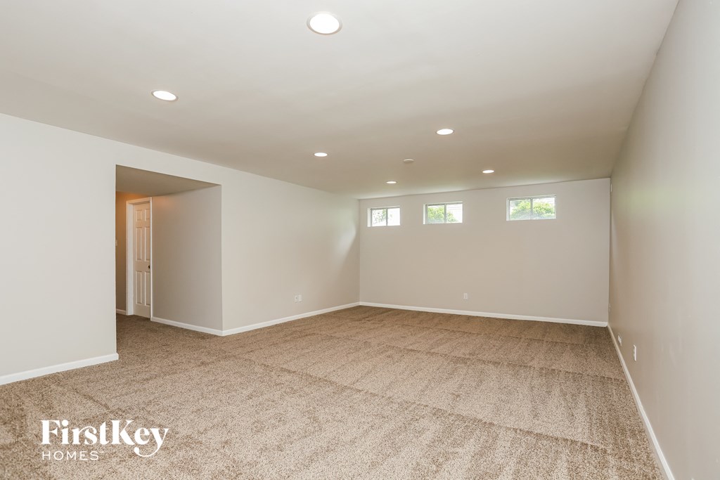 a empty living room with white walls and carpet