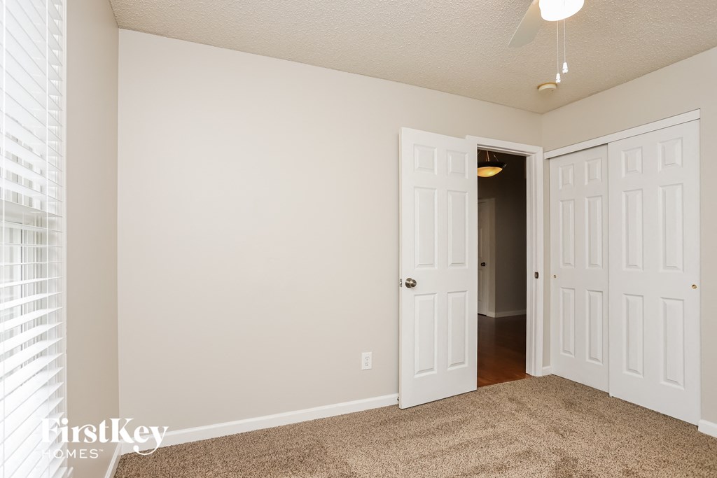 a bedroom with two closets and a door to a hallway
