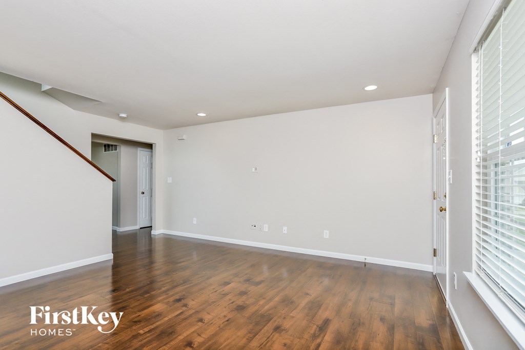 a living room with wood floors and white walls
