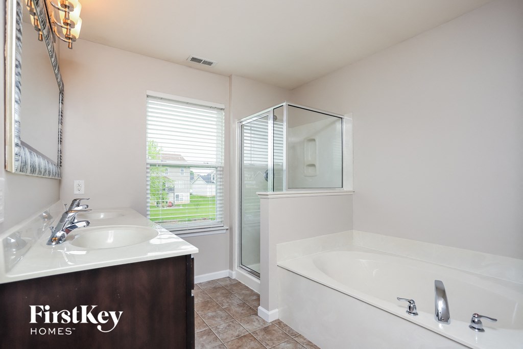 a bathroom with a tub and a sink and a mirror