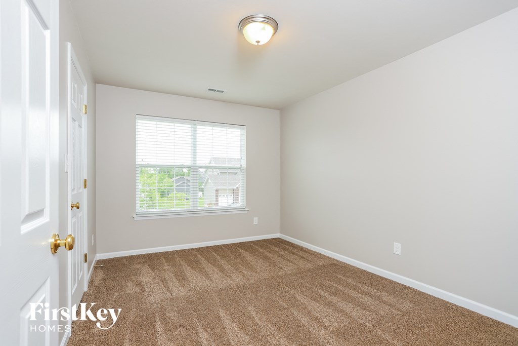 a spacious living room with carpet and a window