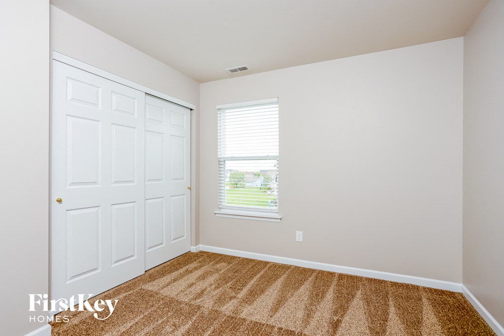 a bedroom with two closets and a window