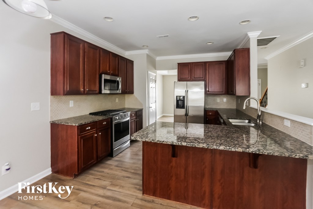 A kitchen with brown cabinets and a granite countertop.