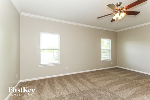 a living room with carpet and a ceiling fan