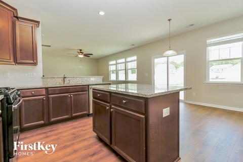 A kitchen with brown cabinets and a marble countertop.