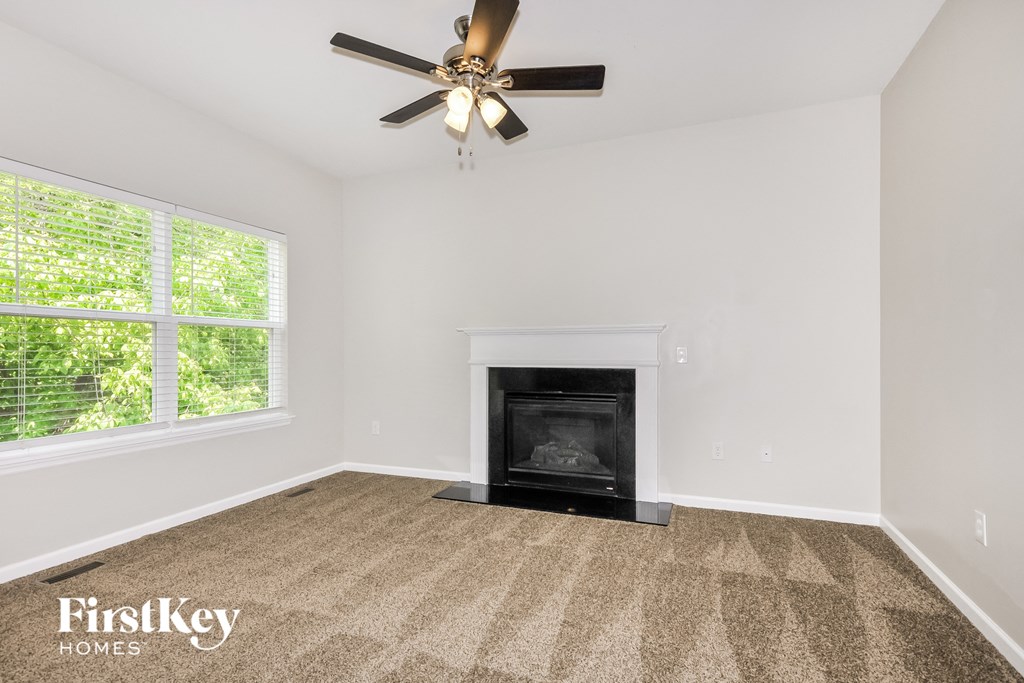 a living room with a fireplace and a ceiling fan