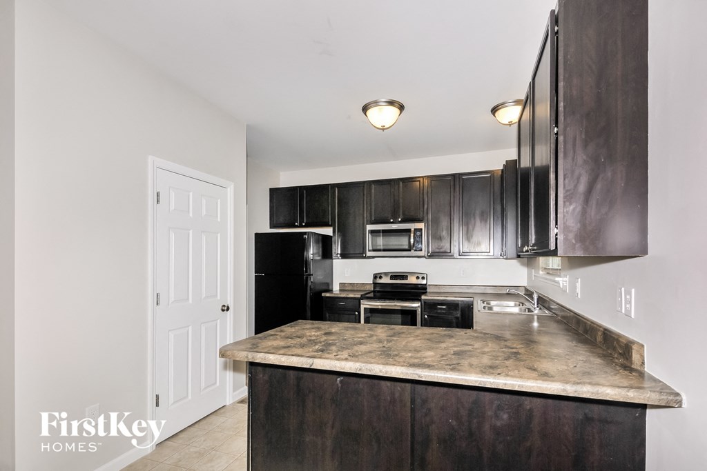 a kitchen with black cabinets and a marble counter top