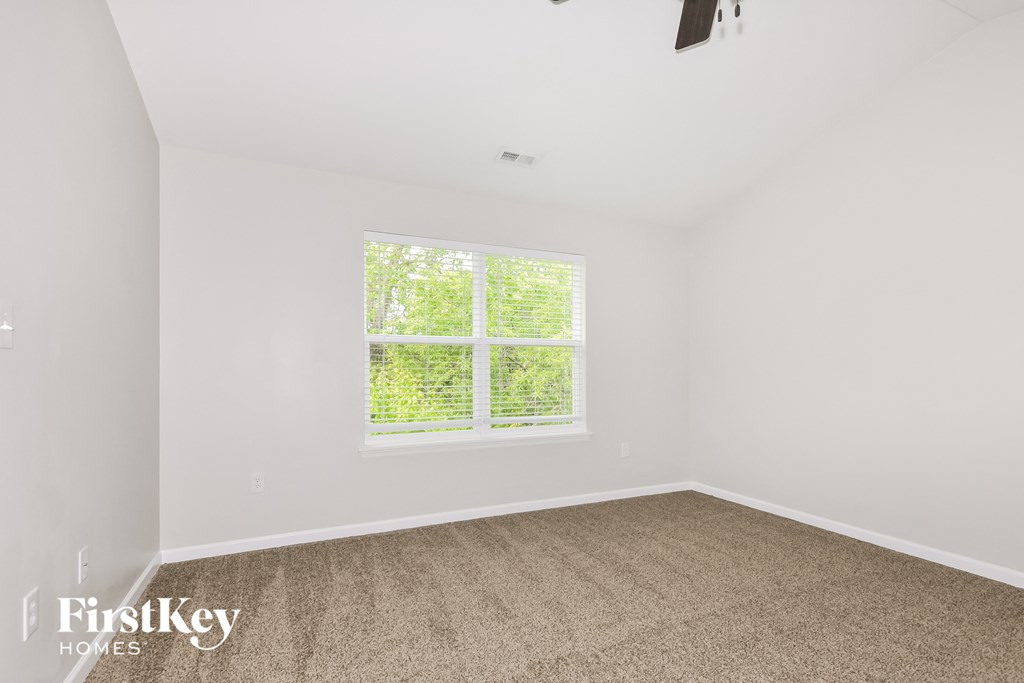 a bedroom with a large window and a carpeted floor