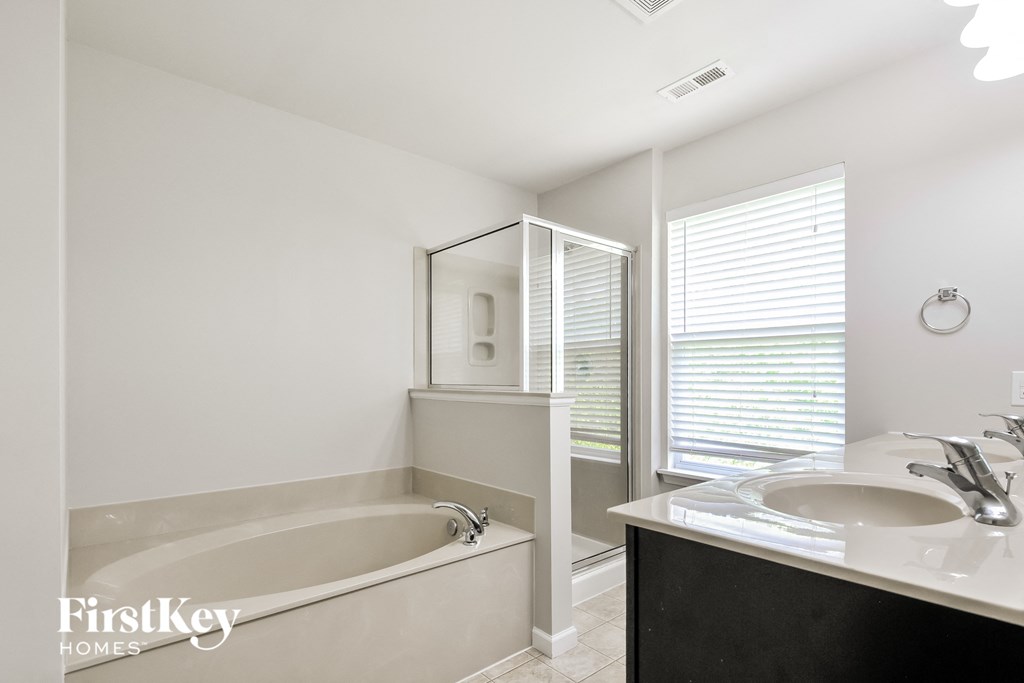 a bathroom with a tub and a sink and a mirror