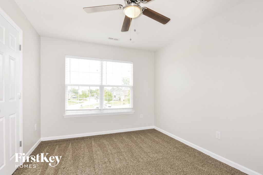 a bedroom with a ceiling fan and a window