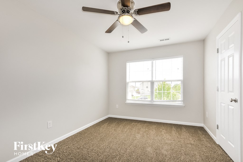 a bedroom with a ceiling fan and a window