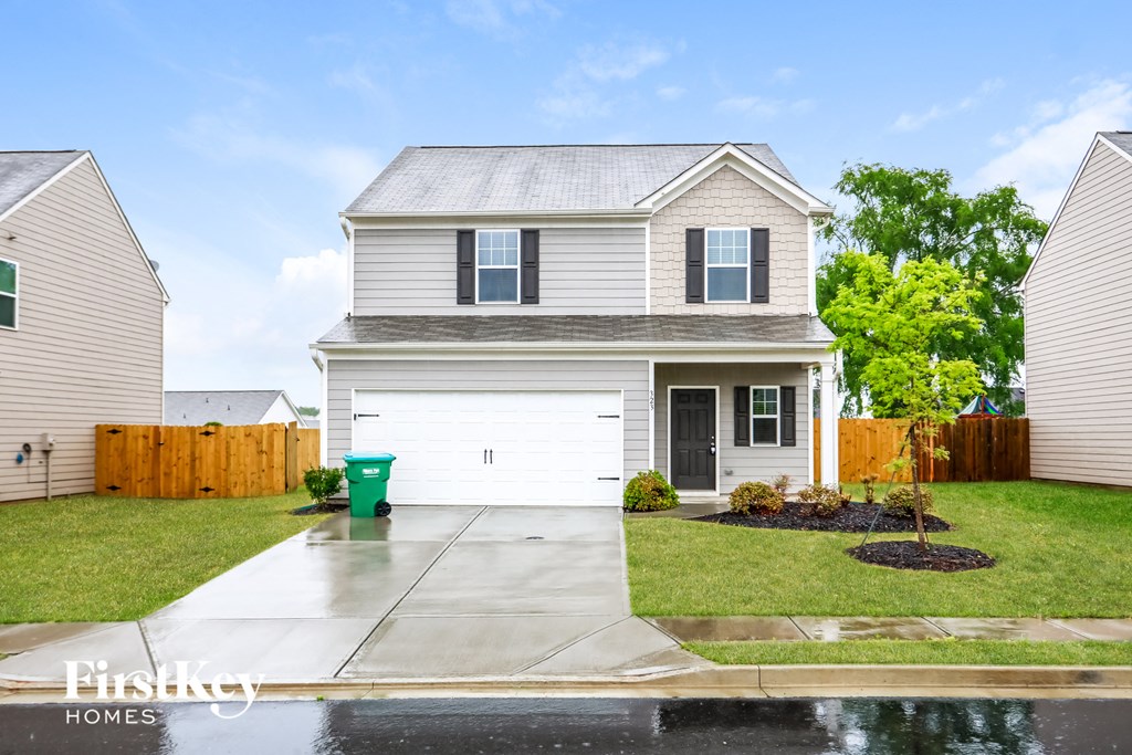 A house with a grey roof and a white garage door.