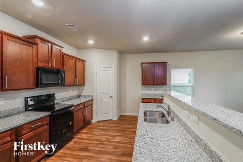 A kitchen with wooden cabinets and a black stove top oven.