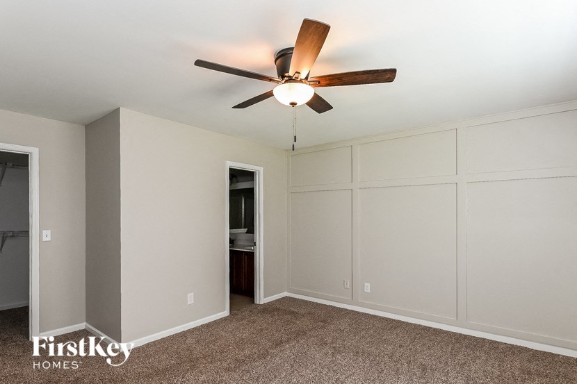 a bedroom with a ceiling fan and a closet