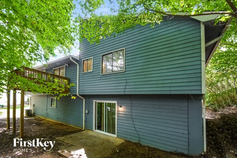 a blue house with blue siding and green trees