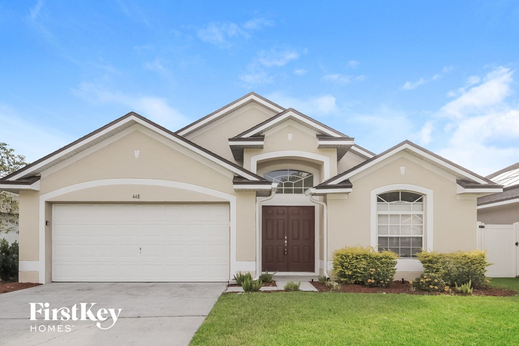 A house with a garage and a brown door.
