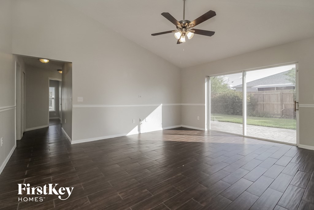 A spacious room with a ceiling fan and wooden flooring.