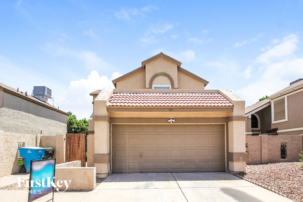 a house with a garage door and a sign in front of it