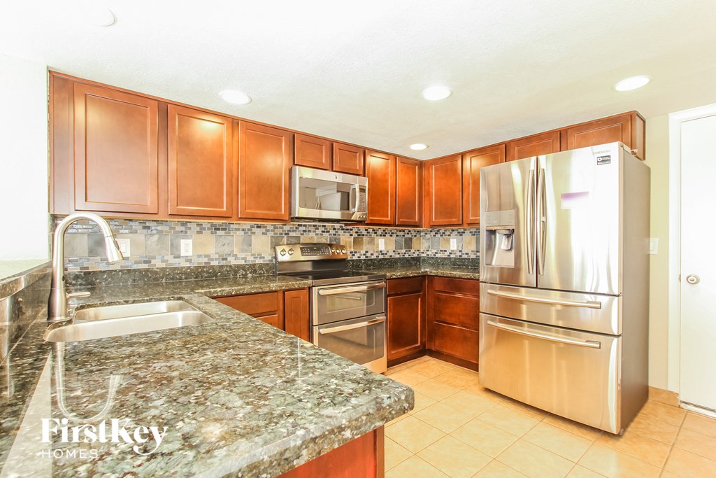 a kitchen with granite counter tops and stainless steel appliances