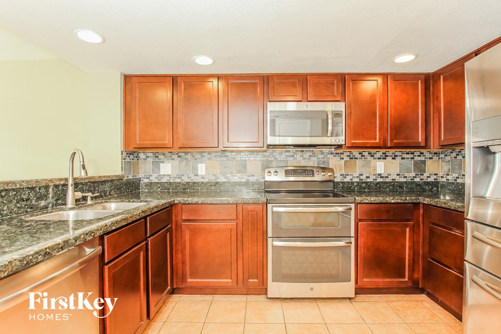 a kitchen with wood cabinets and granite counter tops and stainless steel appliances