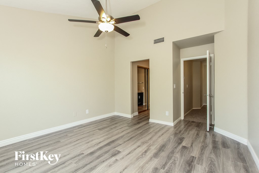 the living room of an empty house with a ceiling fan