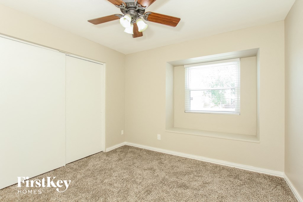 a bedroom with a ceiling fan and a window