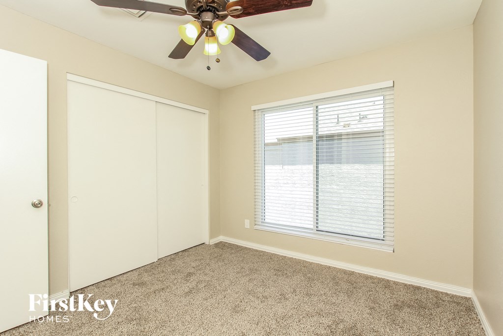 a bedroom with a ceiling fan and a window