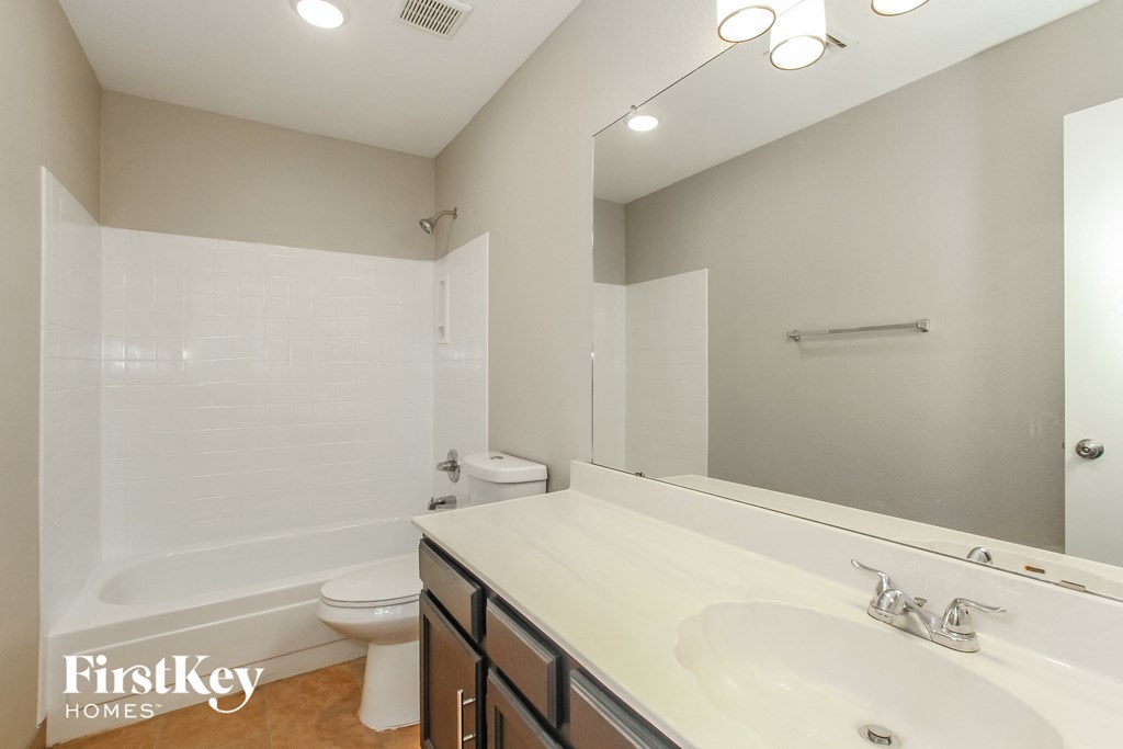 a bathroom with a large mirror and a sink and a toilet