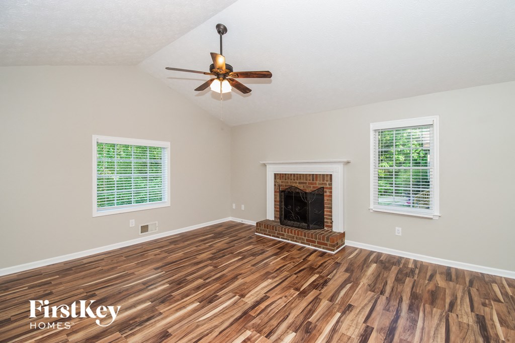 A room with a fireplace and a ceiling fan.