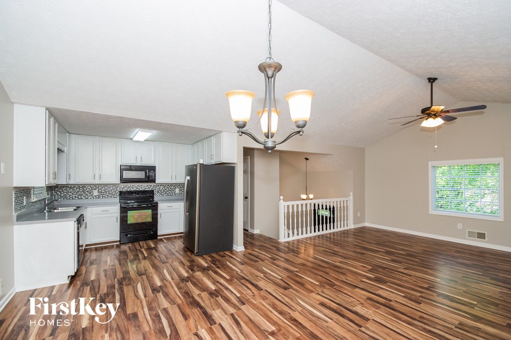 A well-lit kitchen with wooden floors and a chandelier.