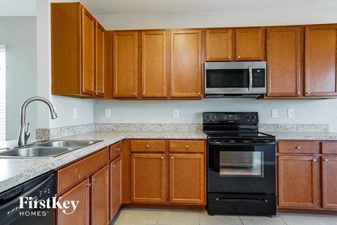 a kitchen with wood cabinets and black appliances and a sink