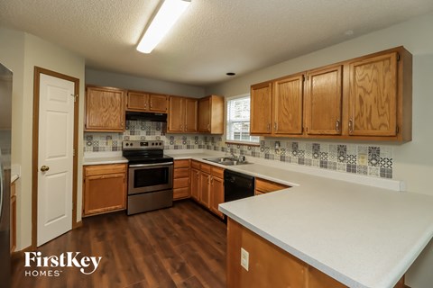 A kitchen with wooden cabinets and a white counter top.