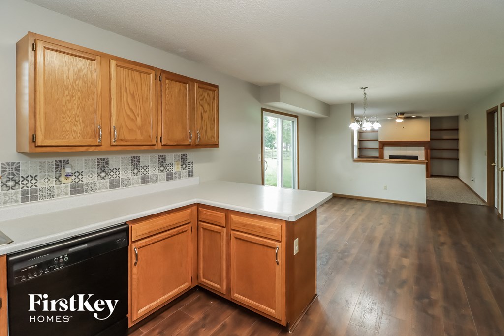 A kitchen with wooden cabinets and a tile backsplash.