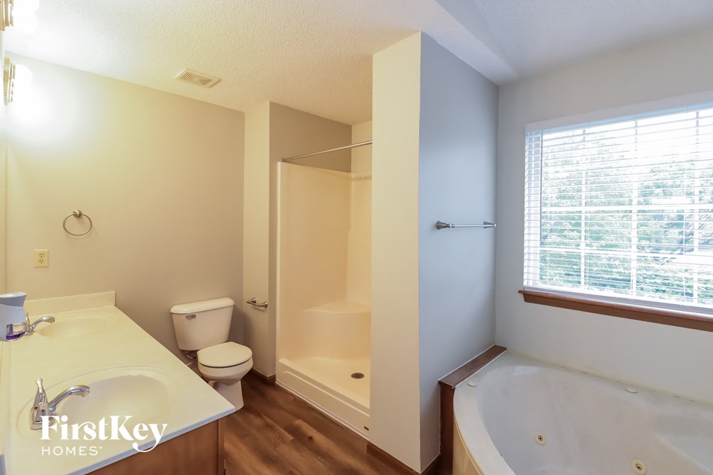 A bathroom with a tub, toilet, and sink.