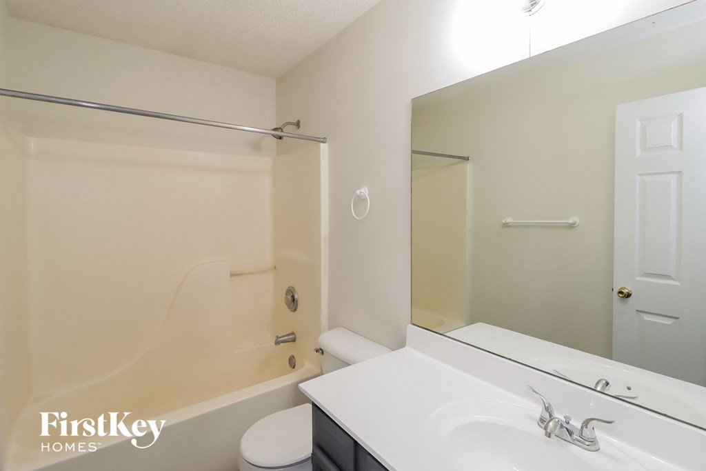 A white bathroom with a tub, toilet, and sink.