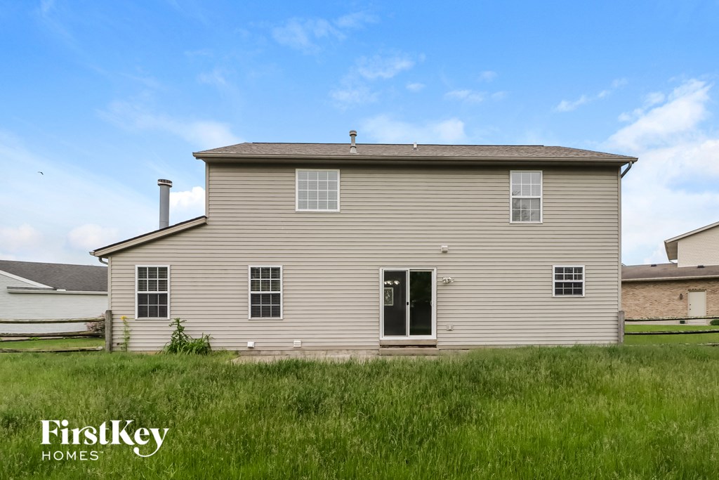 A house with a green lawn in front of it.