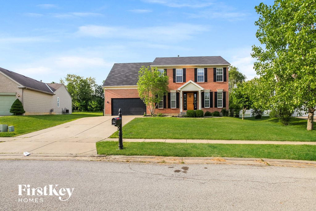 A red brick house with a black mailbox in front.