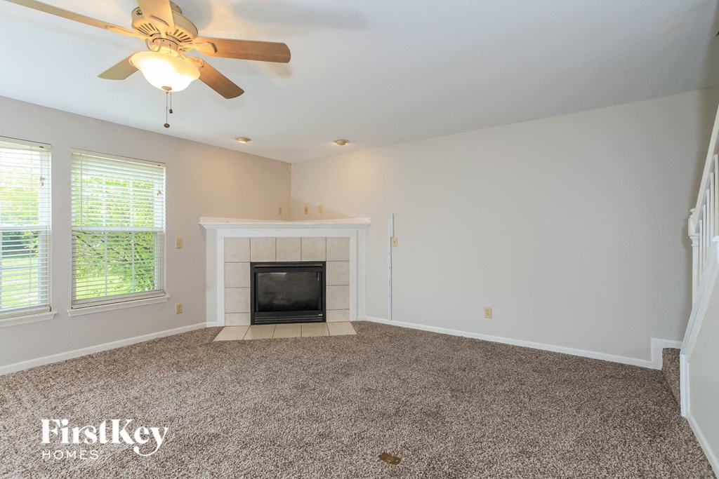 A room with a fireplace and a ceiling fan.