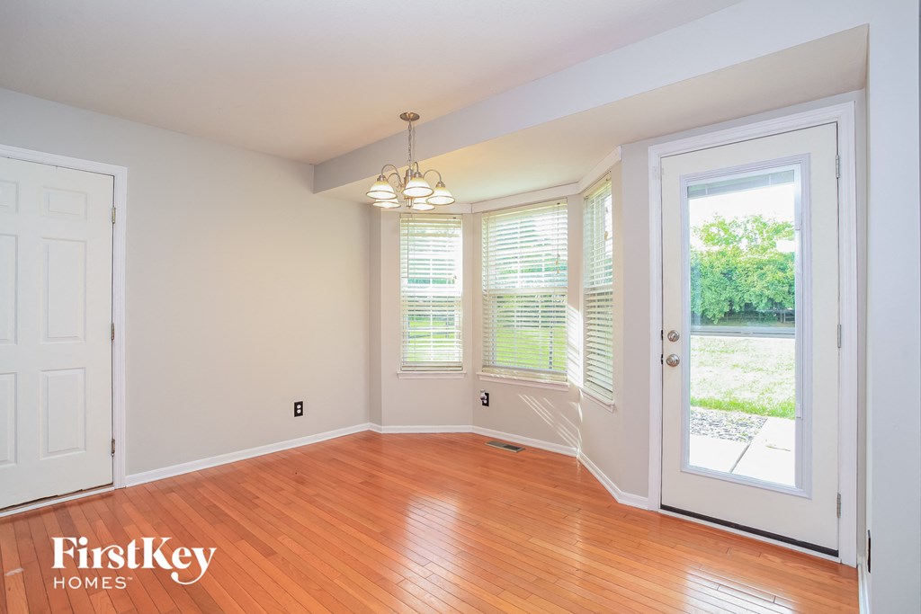 A room with wooden floors and a chandelier.