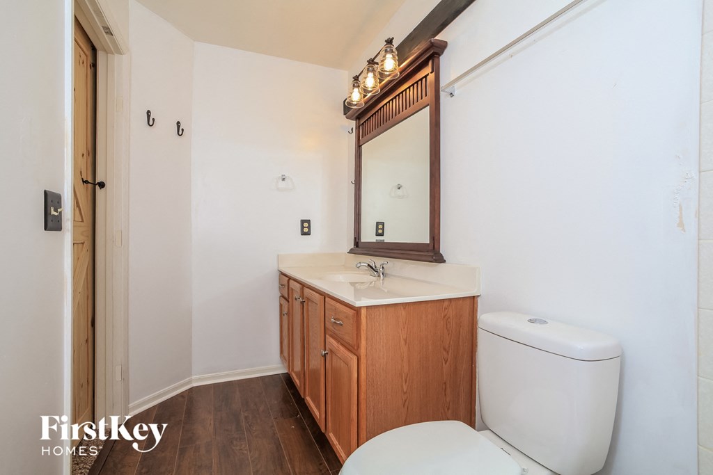 A bathroom with a wooden vanity and a toilet.