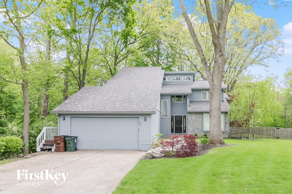 a gray house with a yard and a garage