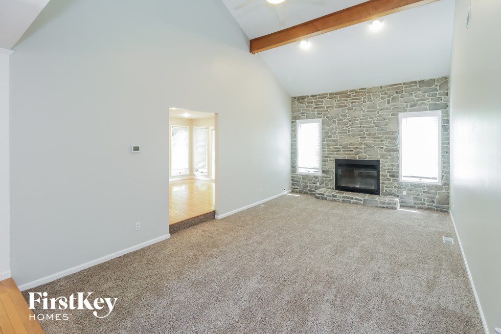 a living room with a fireplace and a carpeted floor