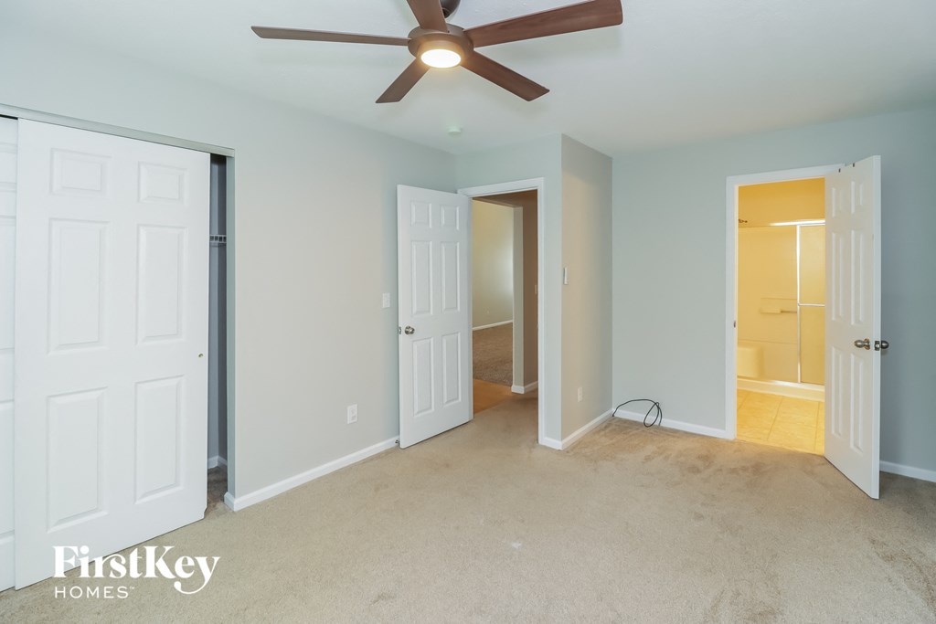a bedroom with two closets and a ceiling fan