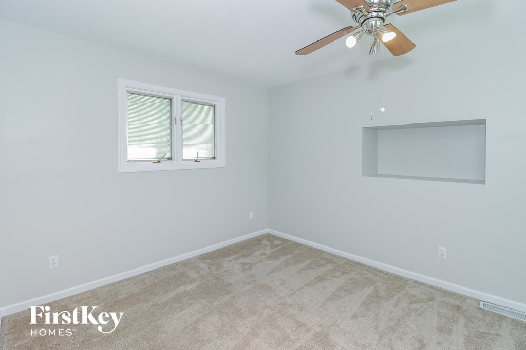 a bedroom with a ceiling fan and a window