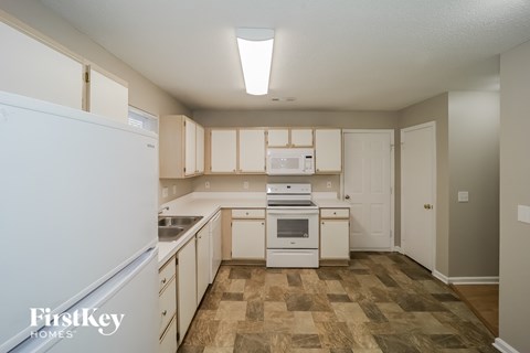 A kitchen with a white fridge and wooden cabinets.