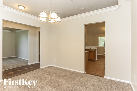 A room with a carpeted floor and a doorway leading to another room.