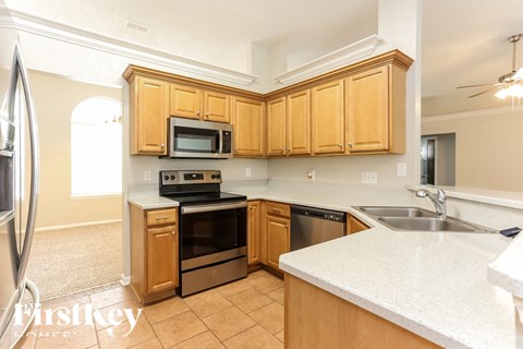 A kitchen with wooden cabinets and a white countertop.
